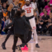 Victor Wembanyama and Mitchell Robinson watch as a fan runs onto the court.