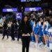 Shannon LeBeauf standing on a basketball court with a team of players.