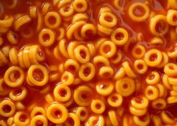 Close-up overhead view of Spaghettio's, a canned pasta consisting of ring-shaped pasta in tomato sauce.