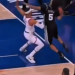 Two basketball players contesting a ball with one player's foot clearly out of bounds.