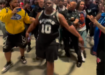 Cops escort the Spurs fan away on June 13, 2026.