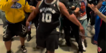 Cops escort the Spurs fan away on June 13, 2026.