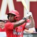 A baseball player in a red helmet and "St. John's" jersey holding a bat.