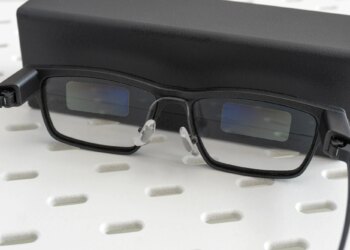 The Xgimi MemoMind One smart glasses leaning against their carrying case.