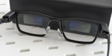 The Xgimi MemoMind One smart glasses leaning against their carrying case.