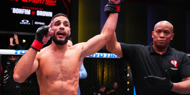 A referee raising Ismael Bonfim's arm in victory at UFC Fight Night: Bonfim vs Brown.