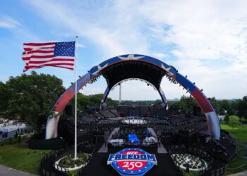 UFC Freedom 250 event setup, with the Octagon in the center, a large American flag waving, and the Washington Monument in the distance.