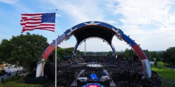 UFC Freedom 250 event setup, with the Octagon in the center, a large American flag waving, and the Washington Monument in the distance.