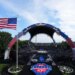 UFC Freedom 250 event setup, with the Octagon in the center, a large American flag waving, and the Washington Monument in the distance.