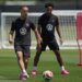 Sergino Dest and Tyler Adams on a soccer field.
