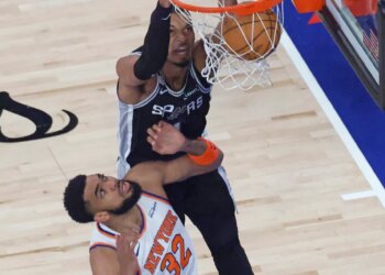 San Antonio Spurs player Victor Wembanyama (1) dunks the ball over New York Knicks player Karl-Anthony Towns (32) during the first quarter.