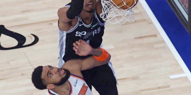 San Antonio Spurs player Victor Wembanyama (1) dunks the ball over New York Knicks player Karl-Anthony Towns (32) during the first quarter.
