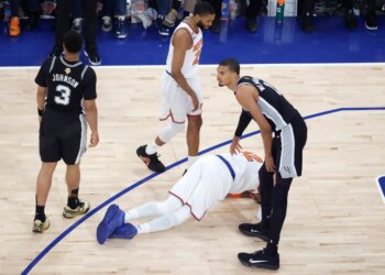 New York Knicks player Karl-Anthony Towns (32) lays on the floor after being fouled by San Antonio Spurs player Victor Wembanyama (1) during the third quarter of Game 4 of the 2026 NBA Finals.