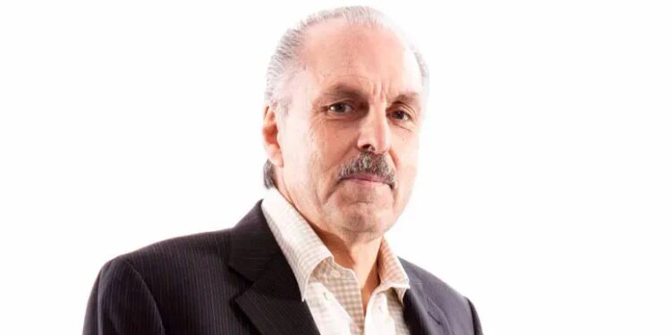 Photo of a man with gray hair and mustache, wearing a suit jacket and collared shirt.