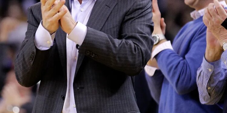 Warriors owner Joe Lacob clapping and smiling, with general manager Mike Dunleavy Jr. laughing next to him.