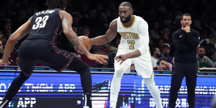 Boston Celtics guard Jaylen Brown dribbling the ball while guarded by Brooklyn Nets center Nic Claxton.