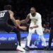 Boston Celtics guard Jaylen Brown dribbling the ball while guarded by Brooklyn Nets center Nic Claxton.
