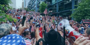 An image collage containing 1 images, Image 1 shows Crowds of fans dressed in red, white, and blue, wave their hands in the air and cheer for the US soccer team in Seattle