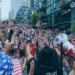 An image collage containing 1 images, Image 1 shows Crowds of fans dressed in red, white, and blue, wave their hands in the air and cheer for the US soccer team in Seattle