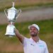 Wyndham Clark holding the U.S. Open golf tournament trophy.