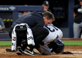 Yankees second baseman Jazz Chisholm Jr. being checked on by a trainer after fouling the ball off his groin.