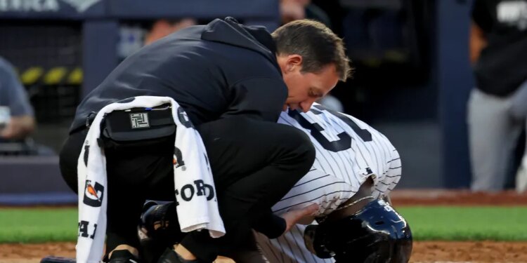 Yankees second baseman Jazz Chisholm Jr. being checked on by a trainer after fouling the ball off his groin.