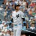New York Yankees left fielder Cody Bellinger wearing a pinstriped uniform, black helmet, and blue accessories, holding a light blue bat.