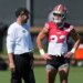 Klay Kubiak smiles at Christian McCaffrey during a practice session.