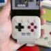 The 8BitDo FlipPad attached to an iPhone held in a person’s hand with a Game Boy game on screen.