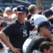 Aaron Judge in the dugout wearing a black Yankees cap and shirt.