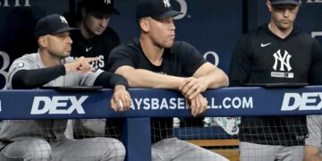 Jake Hirst and Aaron Judge in the dugout during a baseball game.