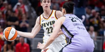 Indiana Fever guard Caitlin Clark (22) passes the ball while Golden State Valkyries forward Cecilia Zandalasini (24) defends.