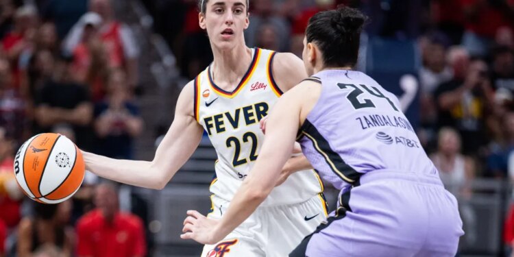 Indiana Fever guard Caitlin Clark (22) passes the ball while Golden State Valkyries forward Cecilia Zandalasini (24) defends.