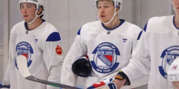 New York Rangers Development Camp players Drew Fortescue and Alberts Smits in white jerseys.