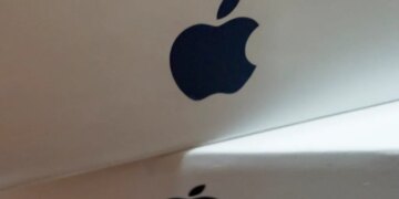 Close-up of a stack of white boxes, each with a dark gray Apple logo on the side.