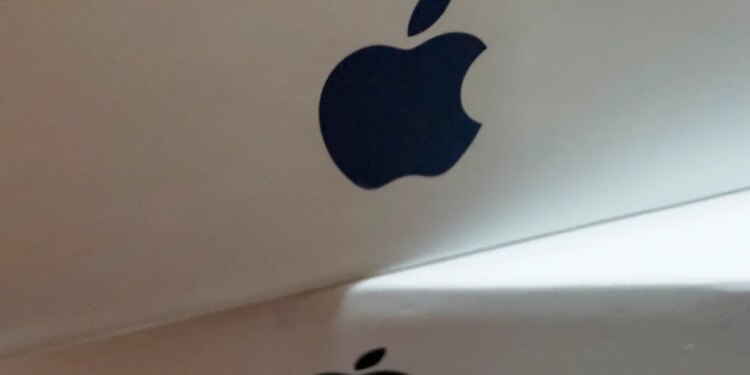 Close-up of a stack of white boxes, each with a dark gray Apple logo on the side.
