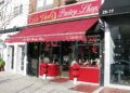 The storefront of La Guli Pastry Shop with a red awning and Christmas decorations in the window.