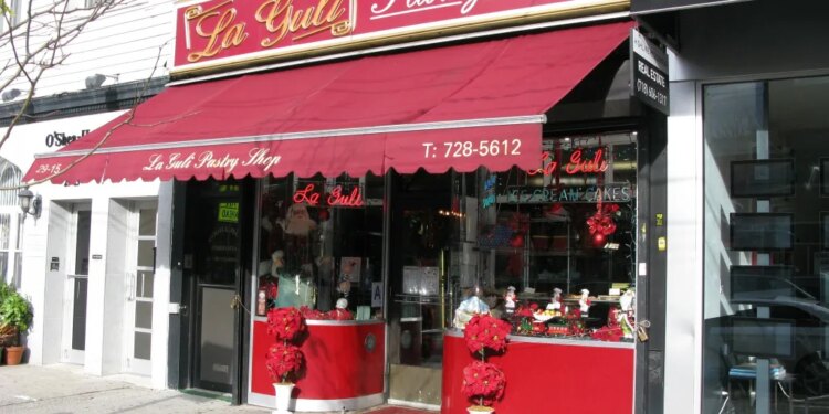 The storefront of La Guli Pastry Shop with a red awning and Christmas decorations in the window.