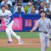 Los Angeles Dodgers' Shohei Ohtani heads to first base as Colorado Rockies pitcher Michael Lorenzen and catcher Braxton Fulford watch.