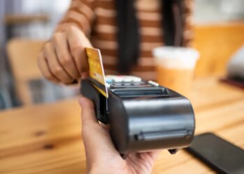A person using a credit card to pay on a payment terminal.