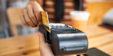 A person using a credit card to pay on a payment terminal.
