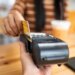 A person using a credit card to pay on a payment terminal.