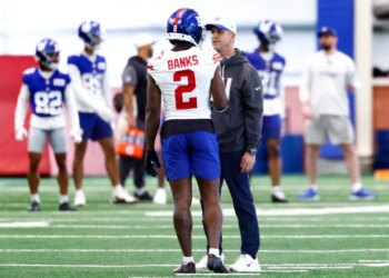 New York Giants cornerback Deonte Banks talking to head coach John Harbaugh during football practice.