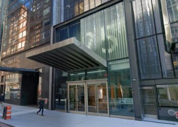 A modern building entrance with a prominent canopy over glass doors and the address 125 above the doors.