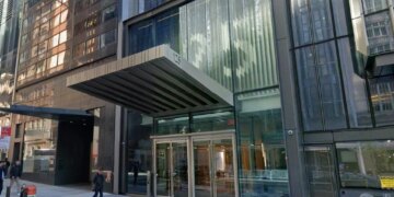 A modern building entrance with a prominent canopy over glass doors and the address 125 above the doors.