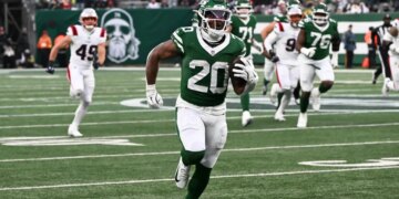 Jets running back Breece Hall (20) runs for a touchdown.