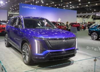 The 2026 Cadillac Vistiq in a vibrant blue color is displayed at the 2025 Detroit Auto Show.