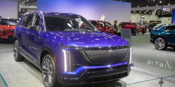 The 2026 Cadillac Vistiq in a vibrant blue color is displayed at the 2025 Detroit Auto Show.
