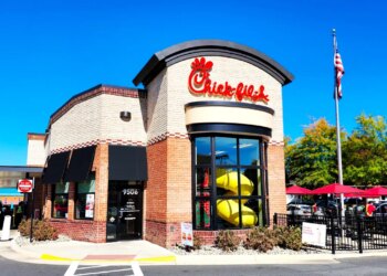Chick-fil-A restaurant exterior in Manassas, Virginia, featuring the logo, drive-thru, and an American flag.