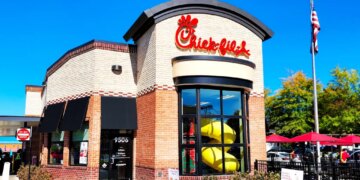 Chick-fil-A restaurant exterior in Manassas, Virginia, featuring the logo, drive-thru, and an American flag.